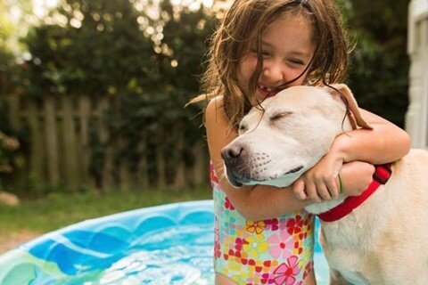 girl at the pool hugging dog